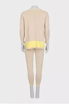 A suit consisting of a jumper with slits and trousers