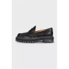 Black leather loafers with white stitching