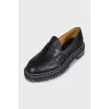 Black leather loafers with white stitching