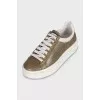 Gold sneakers with white soles