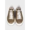 Gold sneakers with white soles