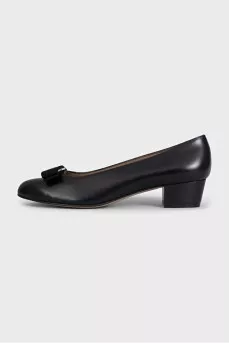 Black leather shoes decorated with a bow