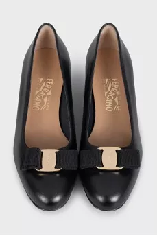 Black leather shoes decorated with a bow