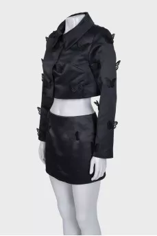 A suit consisting of a cropped jacket and a miniskirt