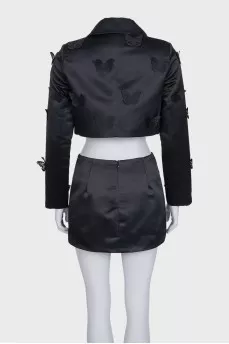 A suit consisting of a cropped jacket and a miniskirt