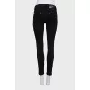 Skinny jeans with a signature brooch
