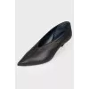 Black leather shoes with a sharp toe