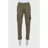 Men's green trousers with a branded patch