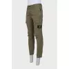 Men's green trousers with a branded patch