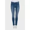 Skinny blue jeans with a logo on the pocket