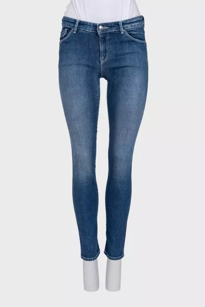 Skinny blue jeans with a logo on the pocket