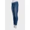 Skinny blue jeans with a logo on the pocket