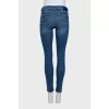 Skinny blue jeans with a logo on the pocket