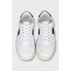Sneakers with black inserts and a tag