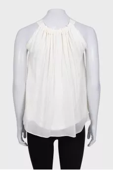 White pleated sleeveless blouse