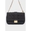 Black leather handbag on a golden chain