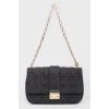 Black leather handbag on a golden chain
