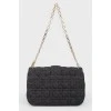 Black leather handbag on a golden chain