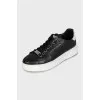 Black leather sneakers with silver logo
