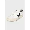 Black and white leather sneakers with a signature logo