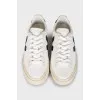 Black and white leather sneakers with a signature logo