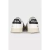 Black and white leather sneakers with a signature logo