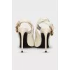 Patent leather slingbacks with a gold pendant