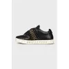 Black leather sneakers decorated with studs