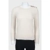 Beige sweater with cuffs on buttons