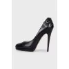 Black leather shoes with embellishments on the back