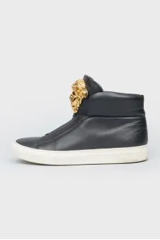 Black leather sneakers with metallic brand logo