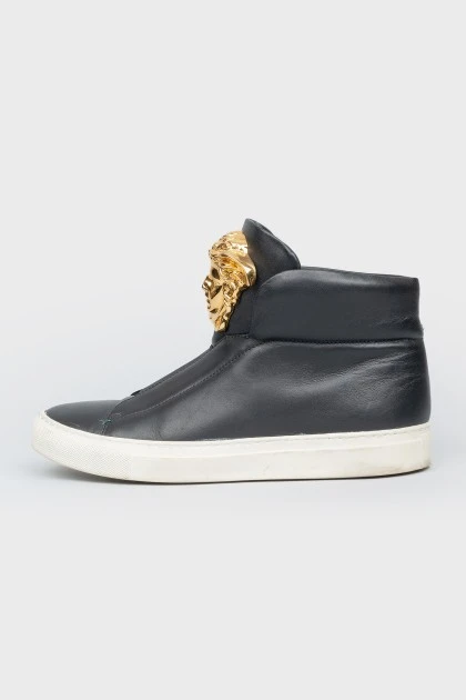 Black leather sneakers with metallic brand logo
