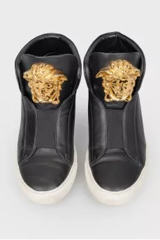 Black leather sneakers with metallic brand logo