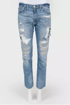 Blue jeans with scuffs and decorative slots