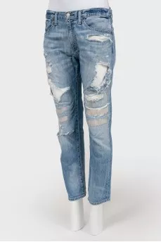 Blue jeans with scuffs and decorative slots