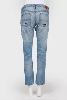 Blue jeans with scuffs and decorative slots
