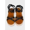 Black leather sandals with a woven sole