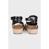 Black leather sandals with a woven sole