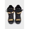 Black leather sneakers with gold hardware