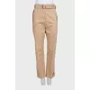Tapered beige trousers with a belt