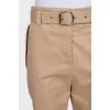Tapered beige trousers with a belt
