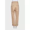 Tapered beige trousers with a belt