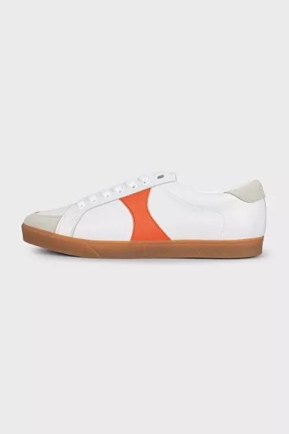 White sneakers with orange inserts and tag