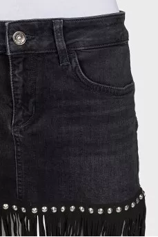 Black denim mini skirt decorated with fringe
