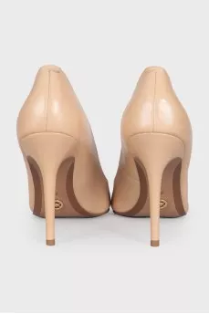 Beige pumps with a gold logo