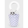 A purple bag with a net and white handles, there is a tag