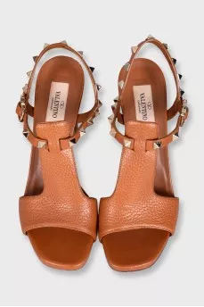 Brown leather heeled sandals decorated with studs
