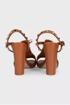 Brown leather heeled sandals decorated with studs