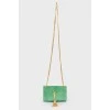 Green sued handbag with golden fittings, on the button