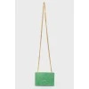 Green sued handbag with golden fittings, on the button